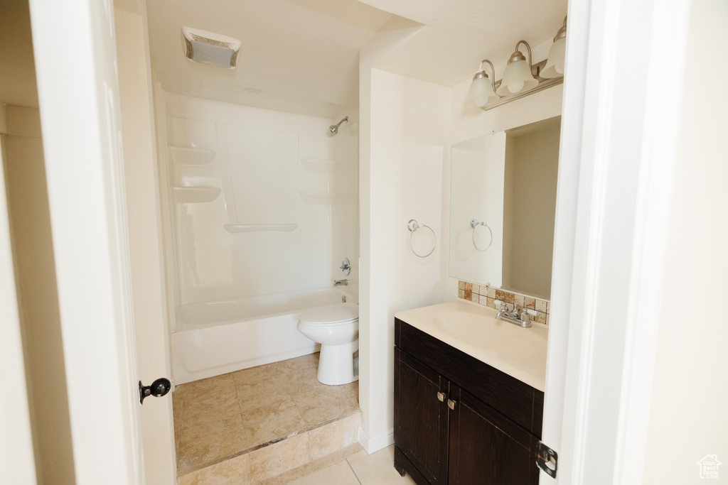 Full bathroom with tile floors,  shower combination, large vanity, and toilet