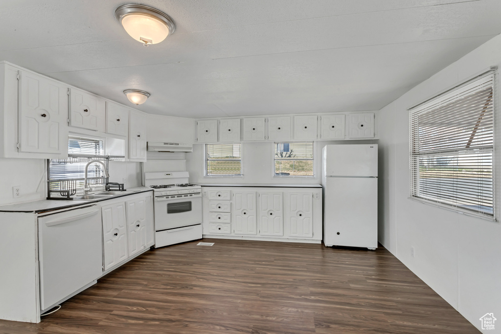 Kitchen featuring dark hardwood / wood-style flooring, white appliances, white cabinets, and sink