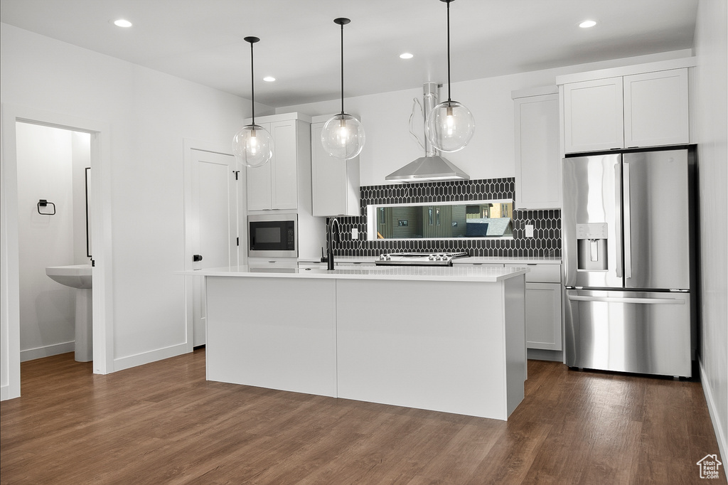 Kitchen featuring pendant lighting, stainless steel fridge, white cabinetry, and dark hardwood / wood-style floors