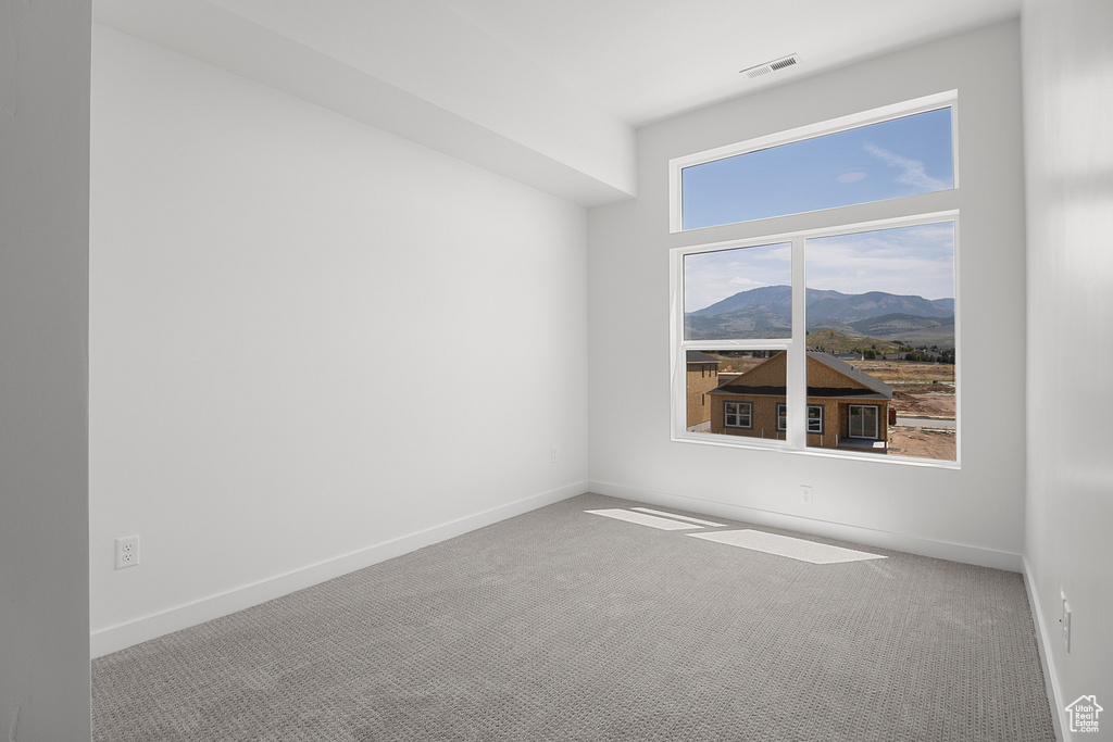 Empty room with a mountain view and light carpet