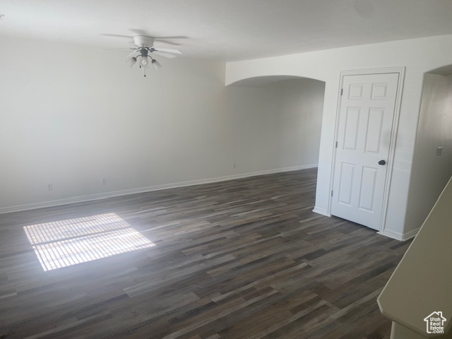 Unfurnished room featuring ceiling fan and dark wood-type flooring