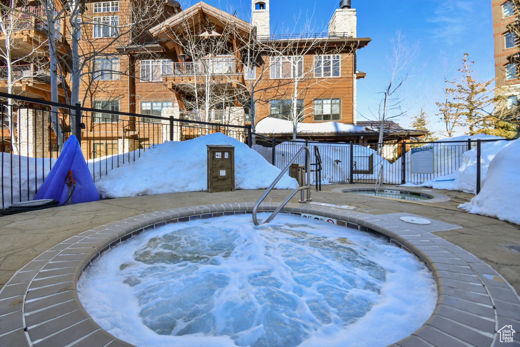 Snow covered pool featuring a community hot tub