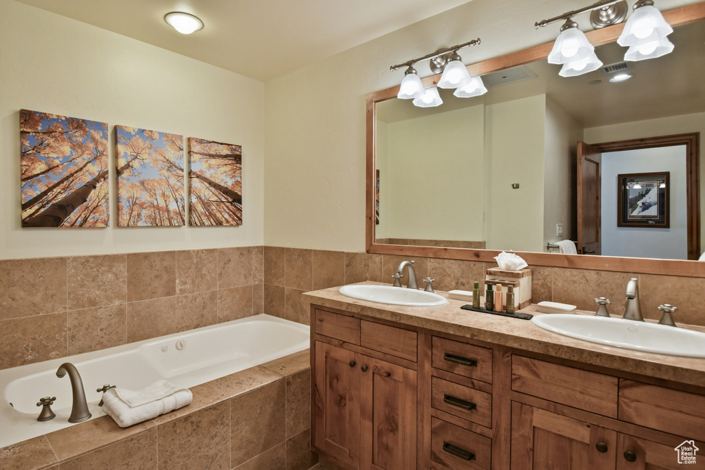 Bathroom with tiled bath and dual vanity