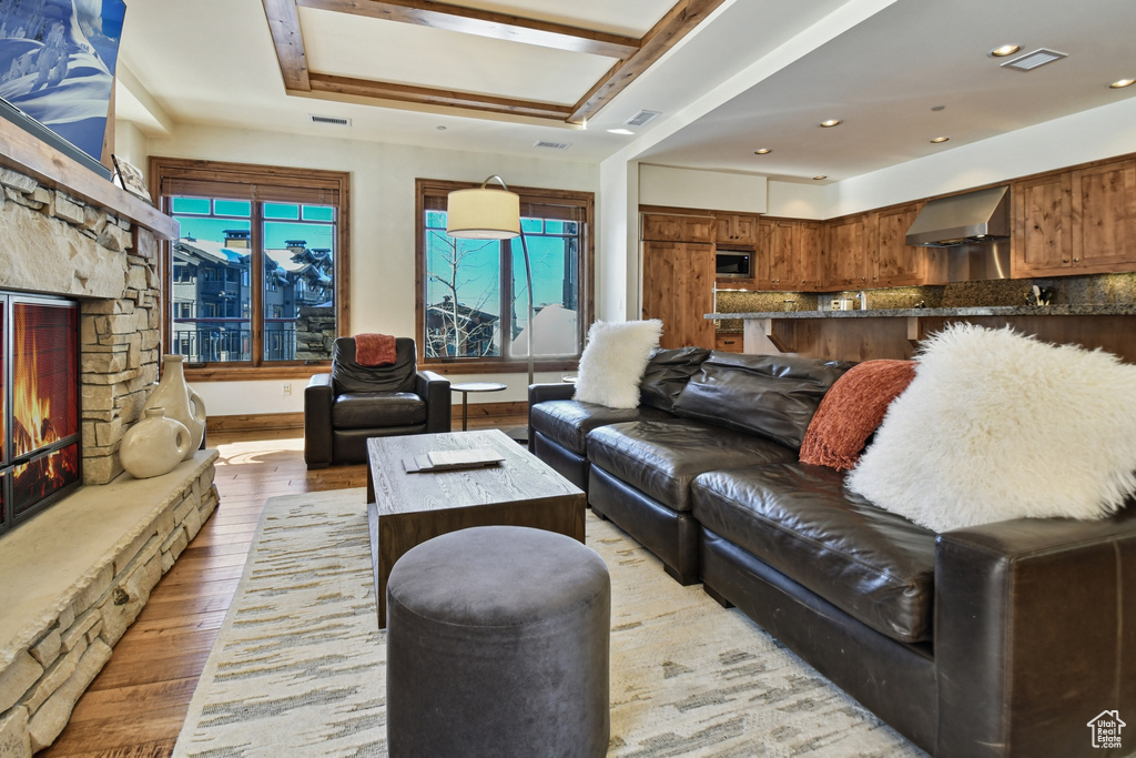 Living room featuring light hardwood / wood-style flooring, a fireplace, and a tray ceiling