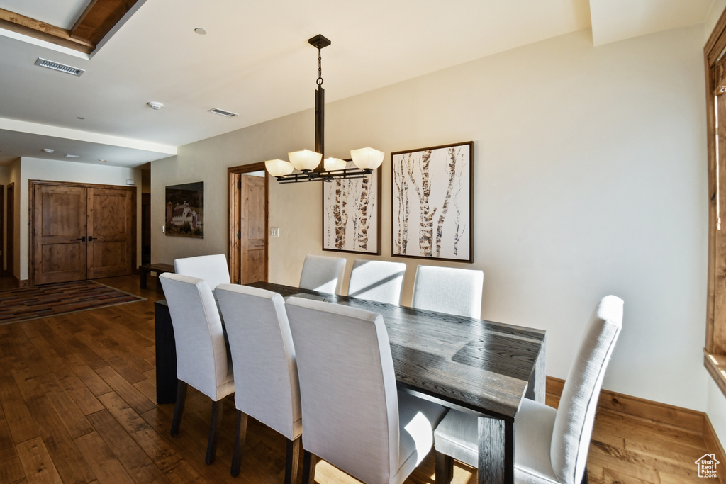 Dining area with dark hardwood / wood-style floors and a chandelier