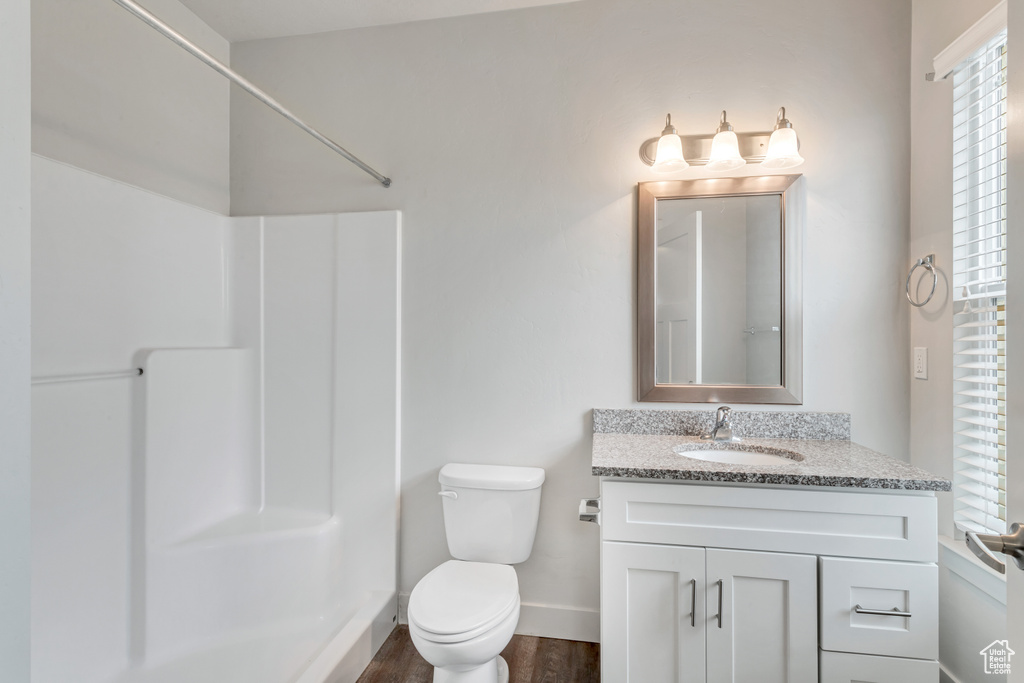 Bathroom with vanity, toilet, a shower, and hardwood / wood-style floors