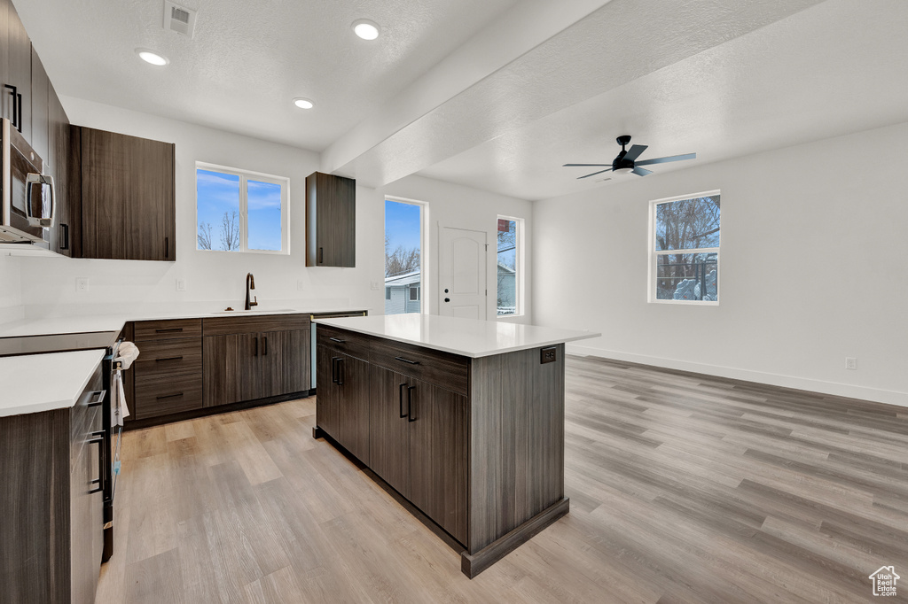 Kitchen featuring a center island, light hardwood / wood-style floors, sink, and ceiling fan