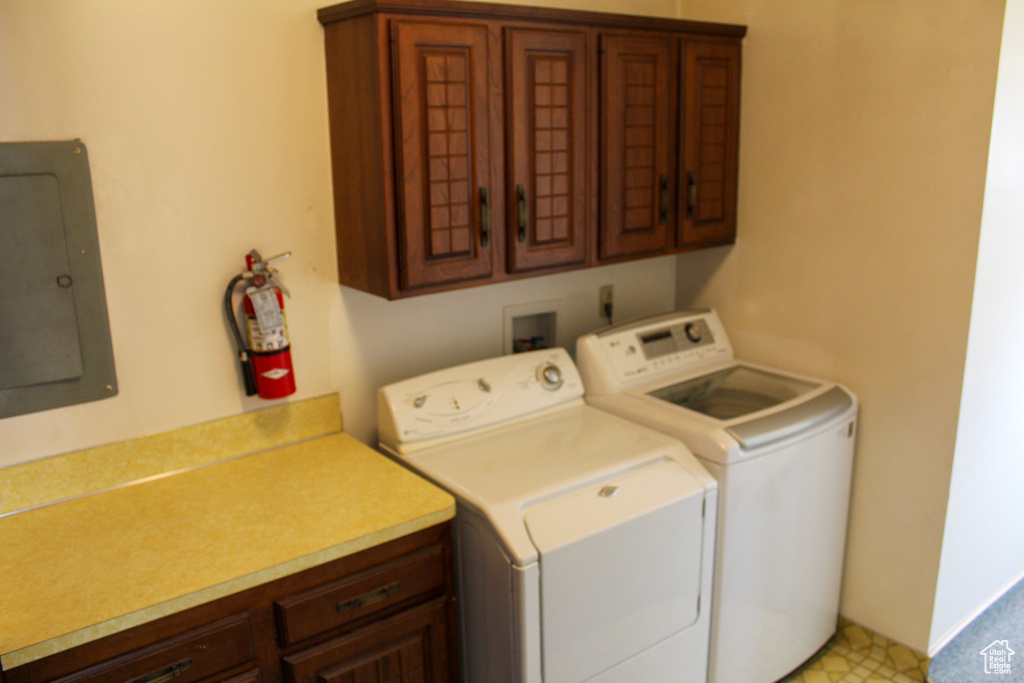 Laundry room featuring washer and dryer, hookup for a washing machine, light tile flooring, and cabinets