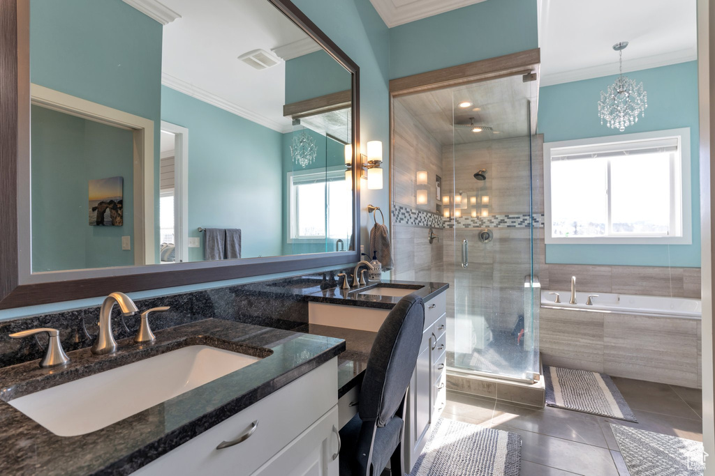 Bathroom with a notable chandelier, plenty of natural light, independent shower and bath, and vanity