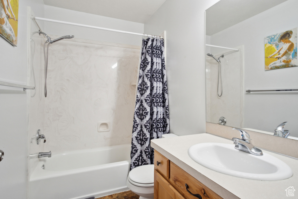 Full bathroom with toilet, vanity, and shower / tub combo with curtain