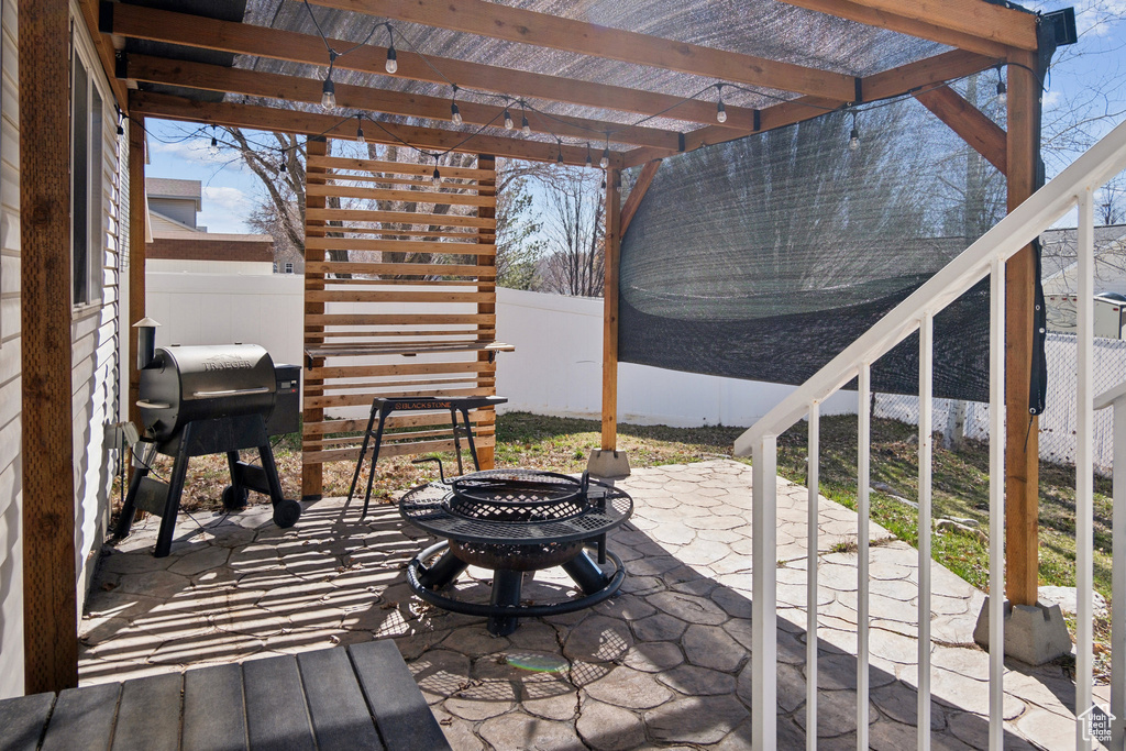 View of terrace featuring a pergola, grilling area, and a fire pit