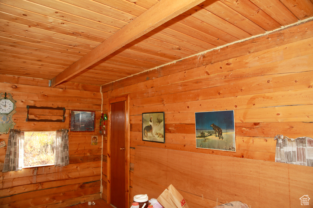 Interior space with wooden walls, wood ceiling, and beamed ceiling