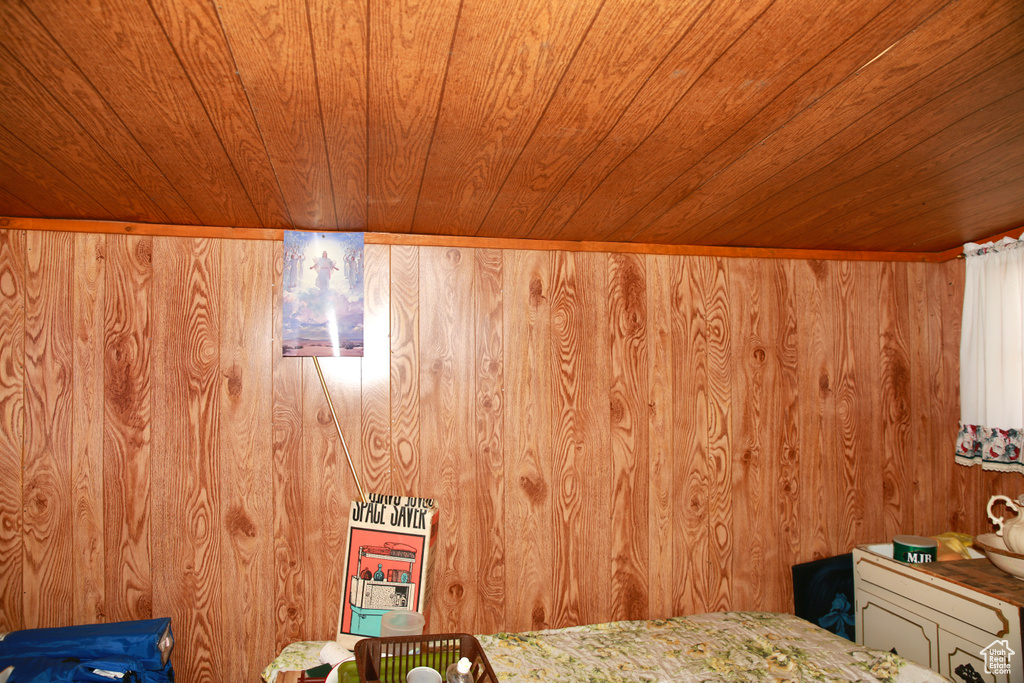 Unfurnished bedroom with wooden walls and wood ceiling