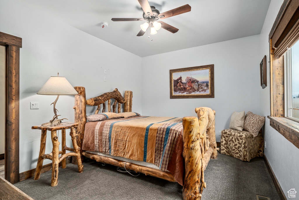 Bedroom with dark carpet and ceiling fan