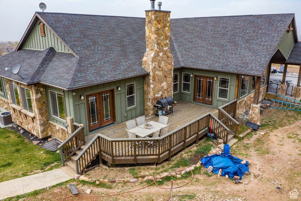 Back of property featuring central air condition unit, a deck, and french doors