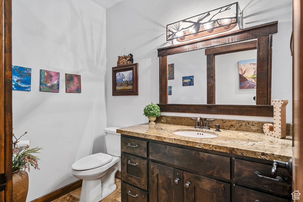 Bathroom with vanity, toilet, and tile flooring