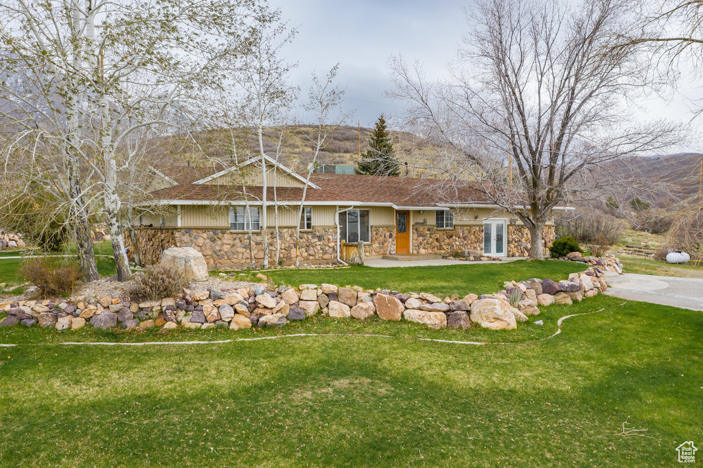 Ranch-style house featuring a patio and a front lawn