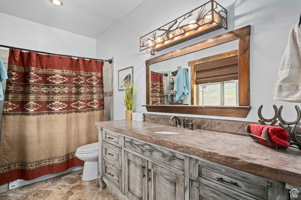 Bathroom featuring vanity, toilet, and tile floors