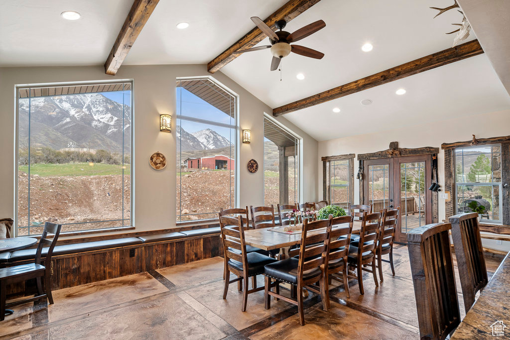 Dining room with vaulted ceiling with beams, french doors, a mountain view, and plenty of natural light