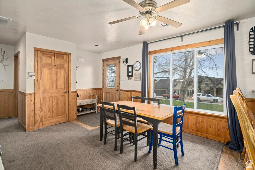 Carpeted dining space featuring ceiling fan