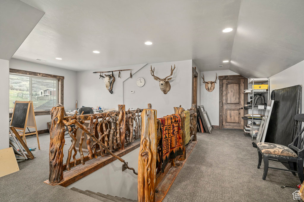 Interior space with vaulted ceiling and dark carpet