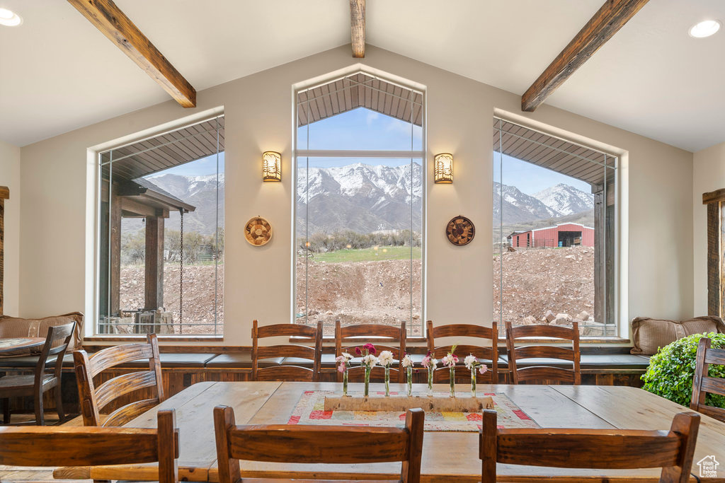 Dining area featuring a mountain view, hardwood / wood-style flooring, and lofted ceiling with beams