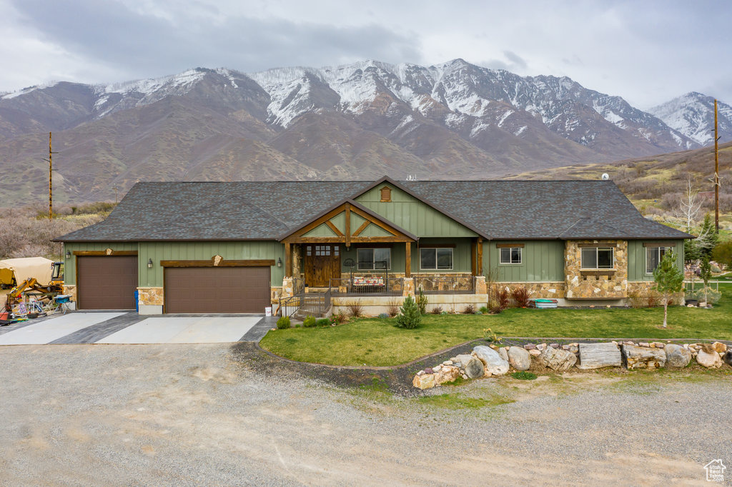 Craftsman inspired home with a mountain view, a garage, and a front yard