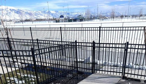 Snow covered gate featuring a mountain view