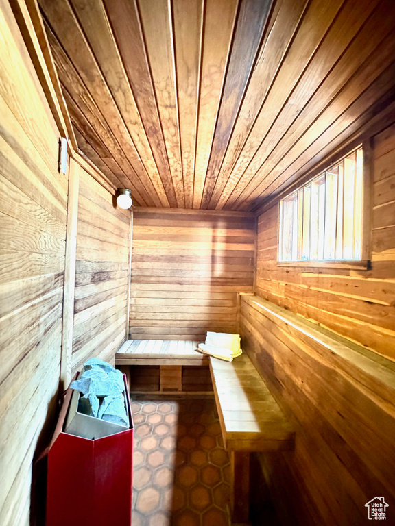 View of sauna / steam room with tile flooring, wood walls, and wood ceiling