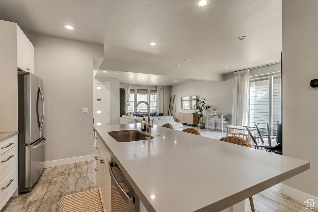 Kitchen featuring white cabinetry, appliances with stainless steel finishes, light hardwood / wood-style flooring, and sink