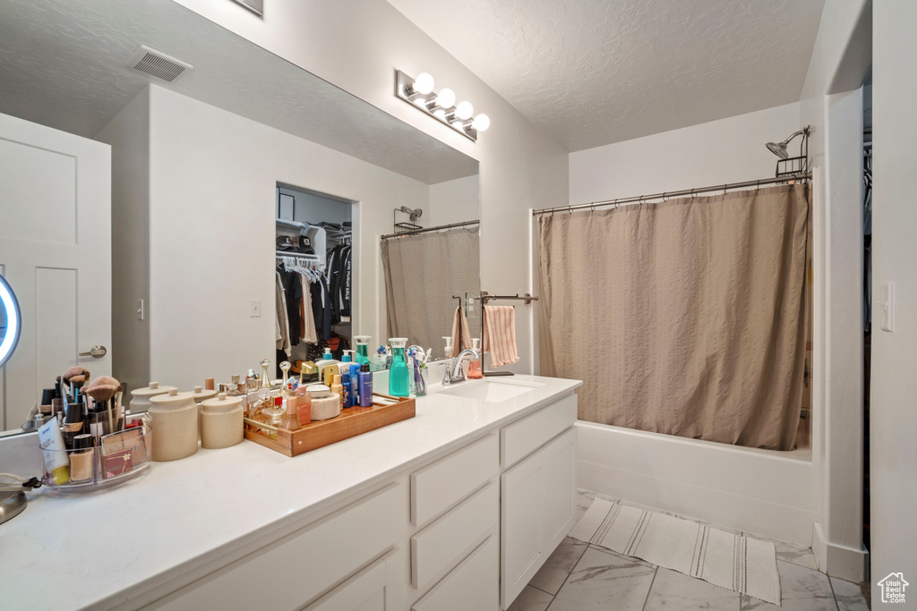 Bathroom with vanity, tile flooring, a textured ceiling, and shower / tub combo with curtain