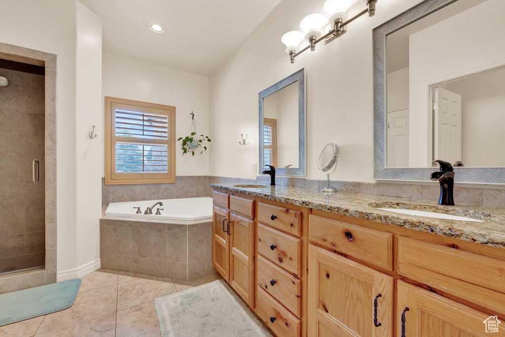Bathroom featuring tile flooring, separate shower and tub, large vanity, and double sink
