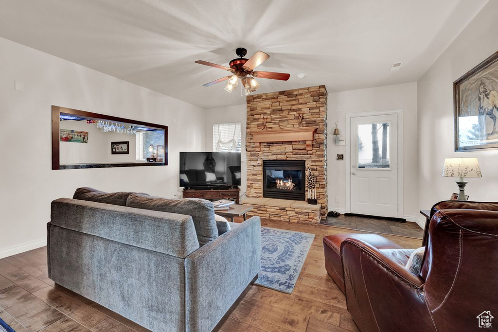 Living room with a fireplace, hardwood / wood-style flooring, plenty of natural light, and ceiling fan