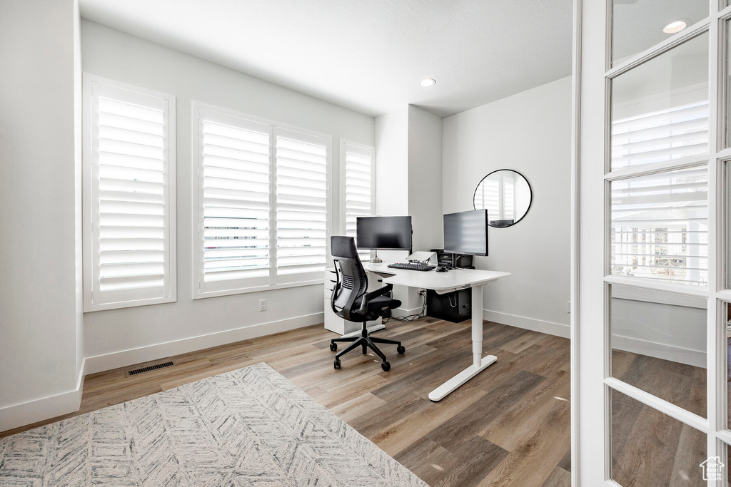 Office area with a wealth of natural light and light wood-type flooring