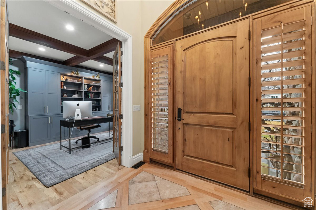 Foyer entrance featuring coffered ceiling, light hardwood / wood-style floors, and beamed ceiling