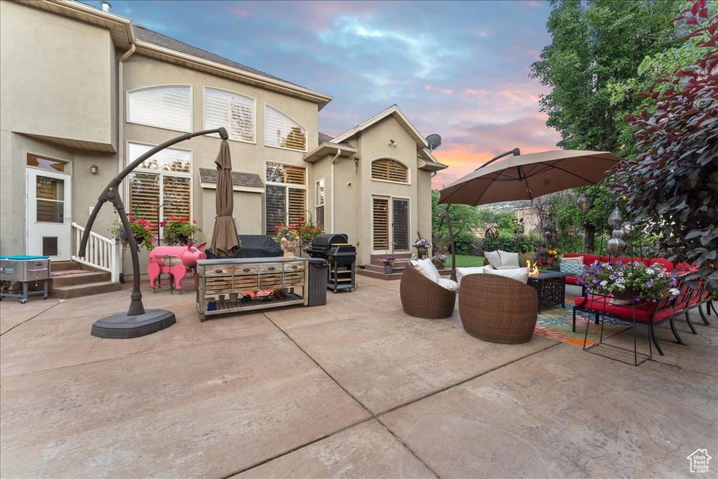 Patio terrace at dusk featuring outdoor lounge area and area for grilling