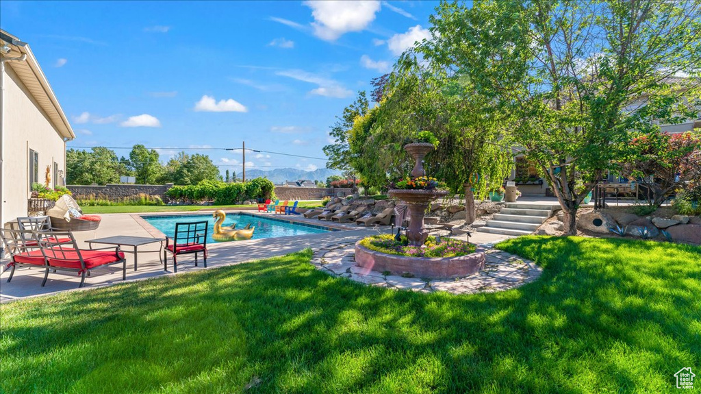 View of swimming pool with a patio and a yard