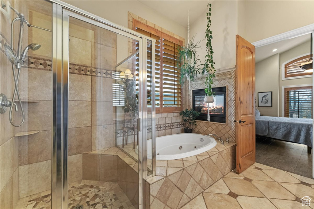 Bathroom with separate shower and tub, a tile fireplace, and tile floors