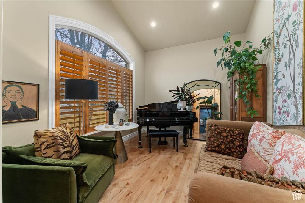 Living room featuring high vaulted ceiling and light hardwood / wood-style flooring