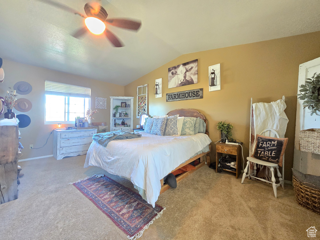 Bedroom featuring vaulted ceiling, light colored carpet, and ceiling fan