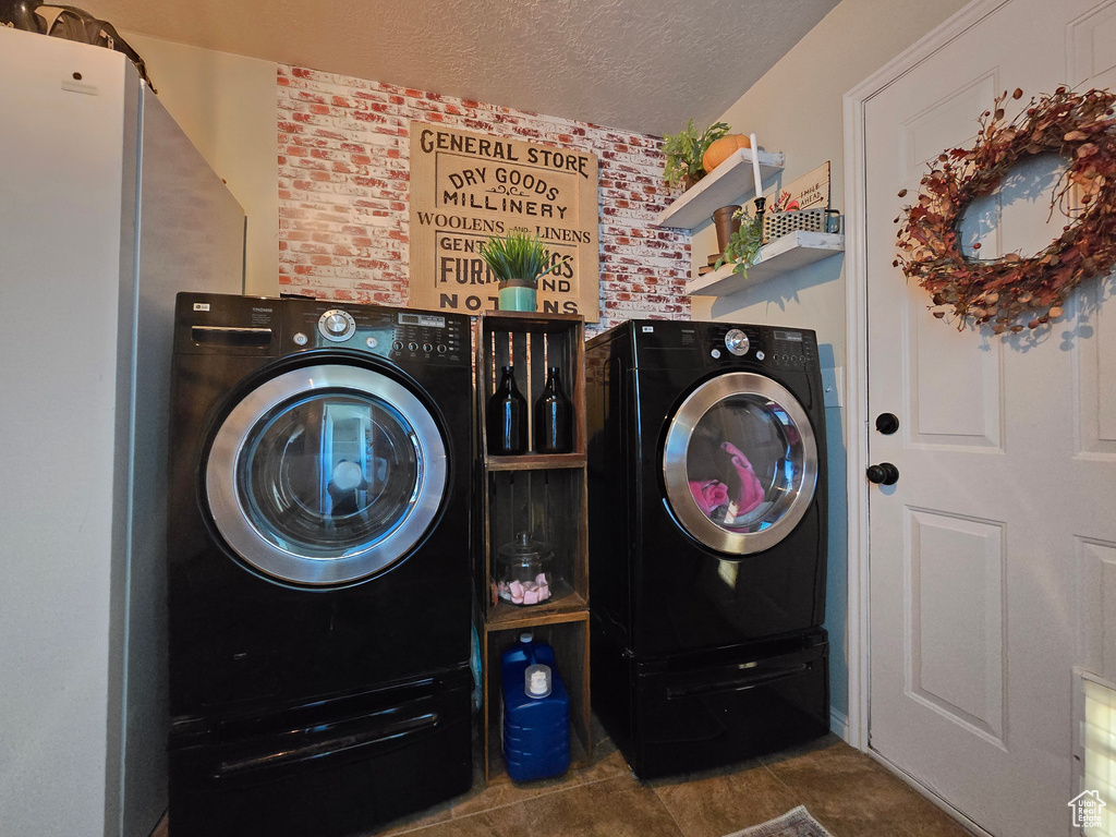 Laundry room featuring a textured ceiling and washer and dryer