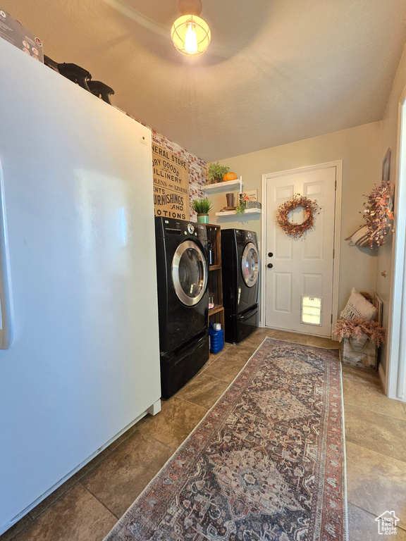 Laundry area featuring separate washer and dryer and tile floors