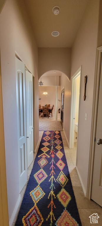 Corridor featuring light tile flooring