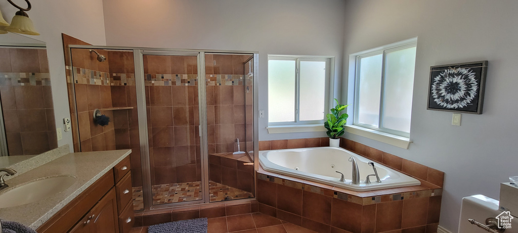 Bathroom featuring vanity, separate shower and tub, a healthy amount of sunlight, and tile floors