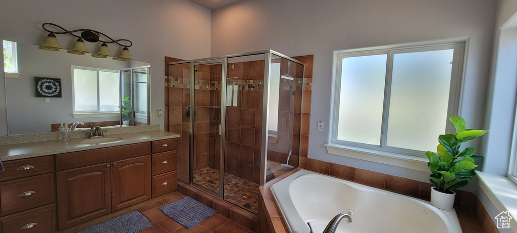 Bathroom with shower with separate bathtub, vanity with extensive cabinet space, and tile flooring