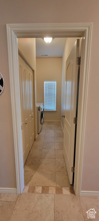 Hall featuring light tile flooring and washer / clothes dryer