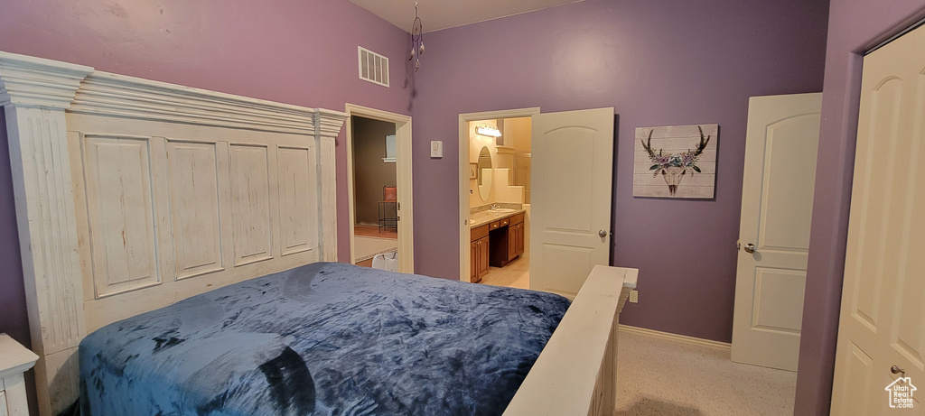 Carpeted bedroom featuring ensuite bath and a closet