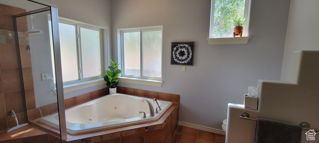 Bathroom featuring plenty of natural light, independent shower and bath, and toilet