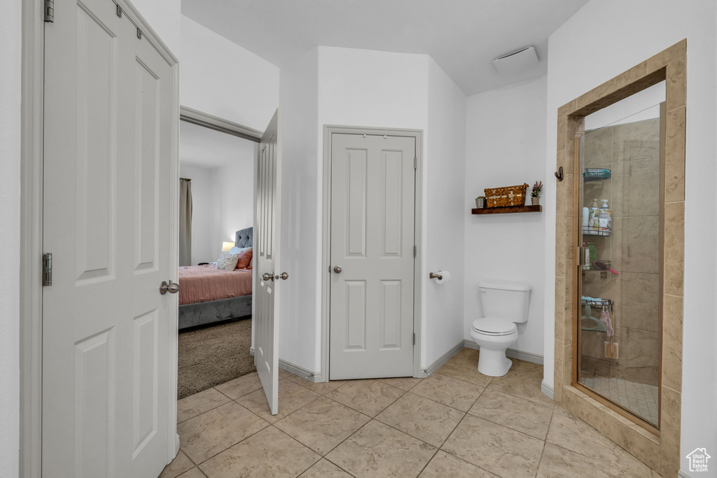 Bathroom featuring tile flooring, toilet, and walk in shower