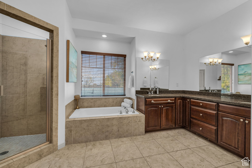 Bathroom with independent shower and bath, tile floors, a wealth of natural light, and vanity